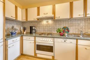 una cucina con mobili bianchi e un lavandino di Wohnung Falkenstein a Spiegelau