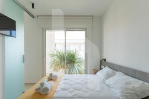 ジュリアノーヴァにあるHomiday - Sublimareのタオルが敷かれた大きなベッドのある寝室