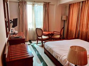 a hotel room with a bed and a desk at Hotel Nikko Towers in Dar es Salaam