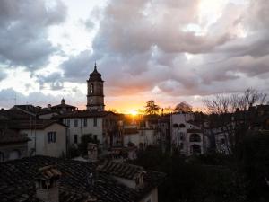 a sunset over a city with a clock tower at Tre Colonne in Terni +34 photos