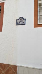 un cartel en el costado de un edificio blanco en Encantadora Casa Andaluza, en Salobreña