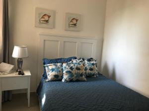 a bedroom with a bed with blue sheets and pillows at Apartamento en Boca Chica T2 501 in Boca Chica