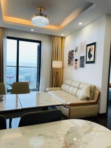 a living room with a couch and a table at LAD Apartment & Homestay Hai Phong - Hoàng Huy Commerce Vo Nguyen Giap in Hai Phong +8 photos