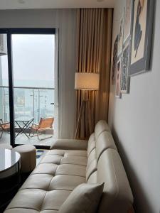 a living room with a couch and a large window at LAD Apartment & Homestay Hai Phong - Hoàng Huy Commerce Vo Nguyen Giap in Hai Phong