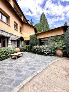 a stone patio with a bench in front of a building at Torre de las Águilas, Bellver, Puigcerdá in Bellver de Cerdanya