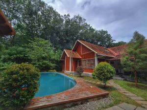 a house with a swimming pool in front of it at Nellu - Tranquil Pool Villa & Organic Farmstay near Varkala in Trivandrum