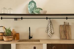 a shelf above a counter with plates and utensils at Almarìa - Le case del Castello - San Nicola L'Arena - Trabia in Trabia +163 photos