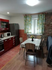 Una cocina y un comedor con mesa y sillas. en Apartmani Cool & Chill, en Gradac