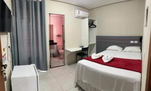 a hotel room with a bed and a bathroom at Nuna Hotel in Goianésia