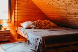 a bedroom with a bed in a log cabin at Polna Przystań 694-272-463 in Uherce Mineralne (7)