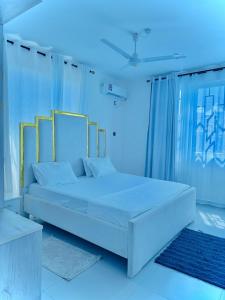 Cama blanca en habitación con luces azules en Tausi Residency, en Mombasa 9 fotos más