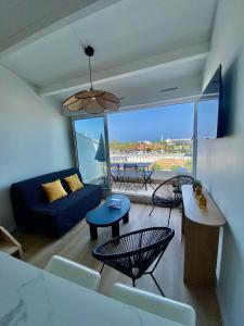a living room with a blue couch and chairs at Village naturiste Appart B Port Soleil in Cap d'Agde