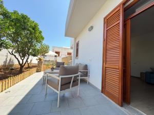 a patio with a table and chairs on the side of a house at Appartamento Ciliegio in San Vito lo Capo