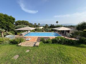 a swimming pool with umbrellas in a yard at Vue mer - Grimaud, France in Port Grimaud