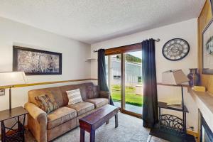 a living room with a couch and a window at Snowdance Condo A101 in Keystone