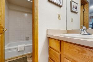 a bathroom with a sink and a bath tub at Snowdance Condo A101 in Keystone +17 photos
