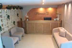 a waiting room with two chairs and a reception desk at Hotel Fontamar 72 in Barranquilla