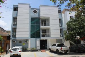 a building with two cars parked in front of it at Hotel Fontamar 72 in Barranquilla
