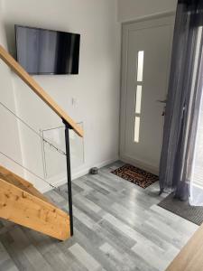 Zimmer mit einer Treppe, einem TV und einer Tür in der Unterkunft appartement entre mer et montagne in Ascain