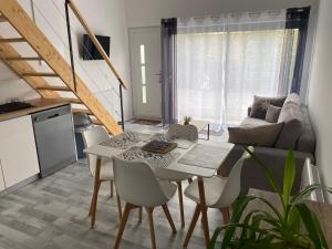 ein Wohnzimmer mit einem weißen Tisch und Stühlen in der Unterkunft appartement entre mer et montagne in Ascain