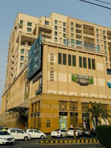 a large building with cars parked in front of it at Skyline Executive Apartments By Gold Crest Mall-DHA LAHORE in Lahore