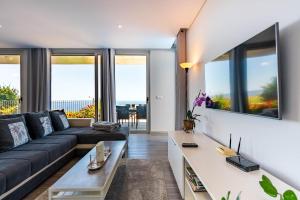 a living room with a couch and a table at Villa Pinheira IV -Heated swimming pool and jacuzzi in Calheta