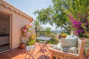 a balcony with a table and chairs and flowers at Lilie House in Bormes-les-Mimosas