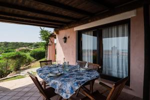 a table with a blue and white table cloth on a patio at Villa Agosto - Piscina privata in Stintino