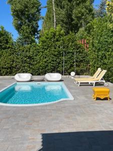 a swimming pool with a yellow chair and a chaise lounge at Appartamento con Vista Mare e Piscina a Casa Vuscichè in Roseto degli Abruzzi