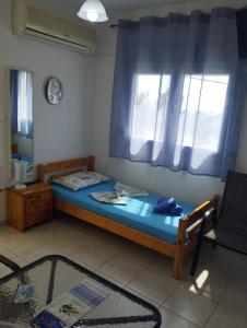 a small bedroom with a bed and a window at Villa Platskos vol3 in Kriopigi