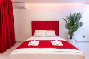 a bedroom with a red bed with two white towels at Wellness & Spa Red Paradise in Donje Mladice