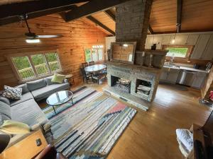 a living room with a couch and a fireplace at Log Cabin w Fireplace, EV Station & River Access in Great Cacapon