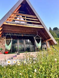 a house with two hammocks on the front of it at Carpathian A-frame in Dragoslavele