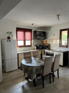 a kitchen with a table and chairs in a kitchen at Apartmani Predovan in Vrsi
