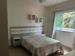 a bedroom with a bed and a large window at Conforto Perto da Praia in Cabo Frio