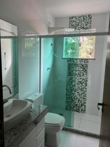 a bathroom with a shower and a toilet and a sink at Conforto Perto da Praia in Cabo Frio +9 photos