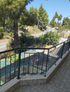a balcony with a fence next to a tree at Villa Platskos vol3 in Kriopigi
