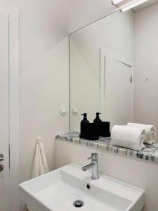 a white bathroom with a sink and a mirror at Casa do Meio #5 in São Martinho do Porto +15 photos