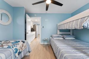 ノース・ワイルドウッドにある301 Ocean Ave, Unit 213 - The Harbor Lightの青い壁の部屋にベッドが2つある