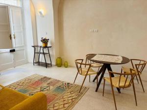 a living room with a table and chairs and a couch at Casa Petra - Santa Croce in Lecce