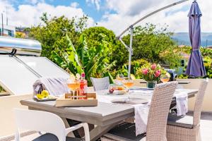 ein Tisch im Freien mit Essen und Getränken auf einem Boot in der Unterkunft Casa do Manuel Maria in Estreito da Calheta