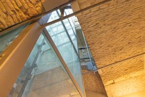 a large glass window in a brick wall at Martini Castello Boutique Apartments - Historic Center & Lift in Cagliari