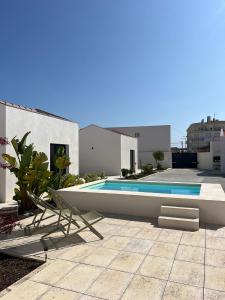 a swimming pool in front of a house at Casa do Meio #5 in São Martinho do Porto