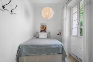 a bedroom with a bed in a white room at Lilie House in Bormes-les-Mimosas