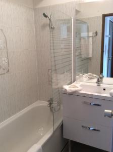 a bathroom with a tub and a sink and a shower at Appart'hôtel Goélia Sun City in Montpellier +11 photos