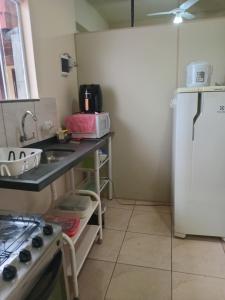 una piccola cucina con lavello e frigorifero di Kitnet Marília a Marília