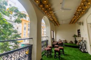a room with a balcony with chairs and green grass at Social Safari Hostel, PARK STREET in Kolkata