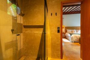 a bathroom with a glass door leading to a bedroom at Boarã Lodge Natureza in Pirenópolis +242 photos