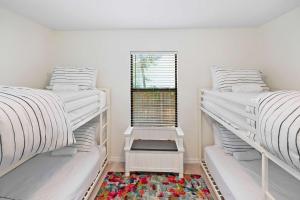 two bunk beds in a room with a window at 3BR Family Getaway Steps to Sand & Sun in Saint Augustine