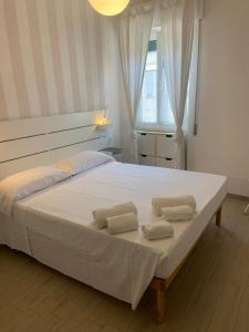 a bedroom with a large bed with two towels on it at Alerì Central Apartment - Zona Pedonale in Viareggio